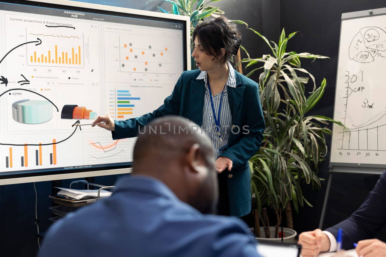 Business affiliates working together on new tasks in a boardroom, reviewing success metrics and key performance indicators to measure efficiency. Workers accomplishing enterprise objectives.