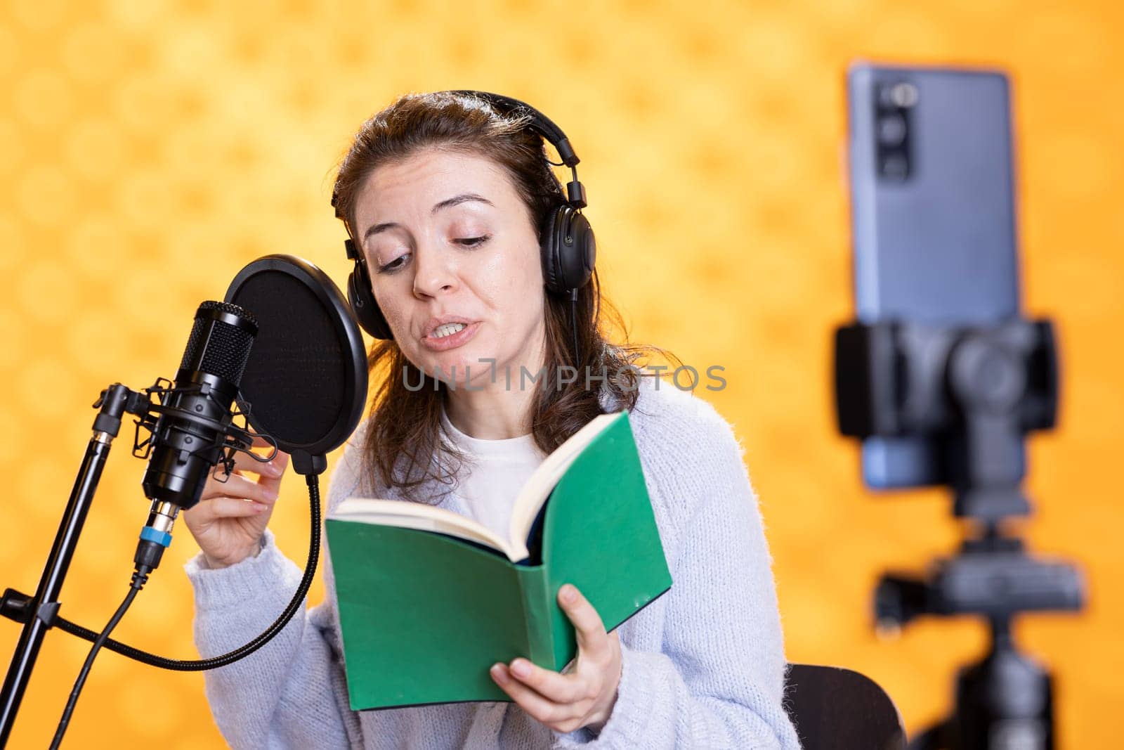 Narrator doing content creation while recording audiobook, studio background by DCStudio