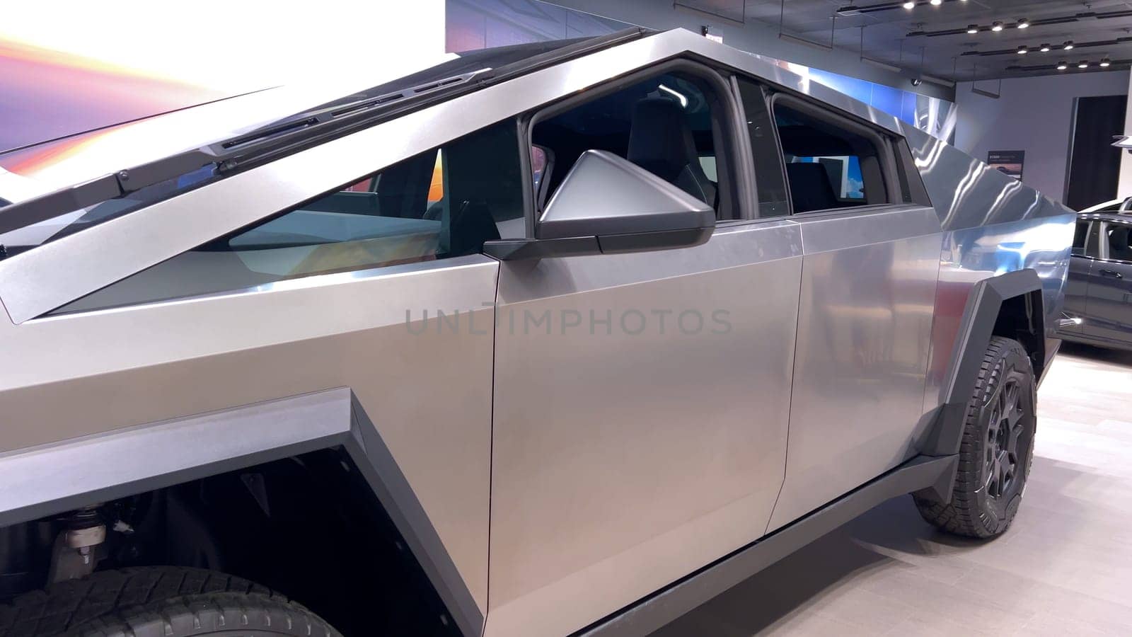 Colorado Springs, Colorado, USA-March 23, 2024-The futuristic Tesla Cybertruck takes center stage in the showroom of a Tesla store, with interested visitors and sleek car designs in the backdrop, all within the Park Meadows Mall.