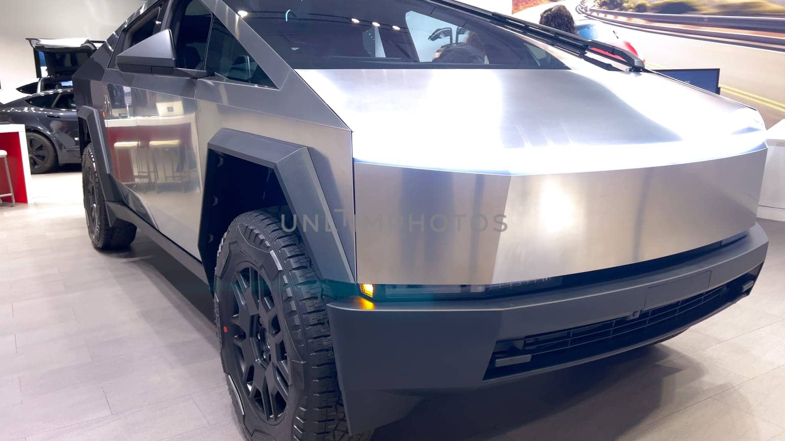 Colorado Springs, Colorado, USA-March 23, 2024-The futuristic Tesla Cybertruck takes center stage in the showroom of a Tesla store, with interested visitors and sleek car designs in the backdrop, all within the Park Meadows Mall.