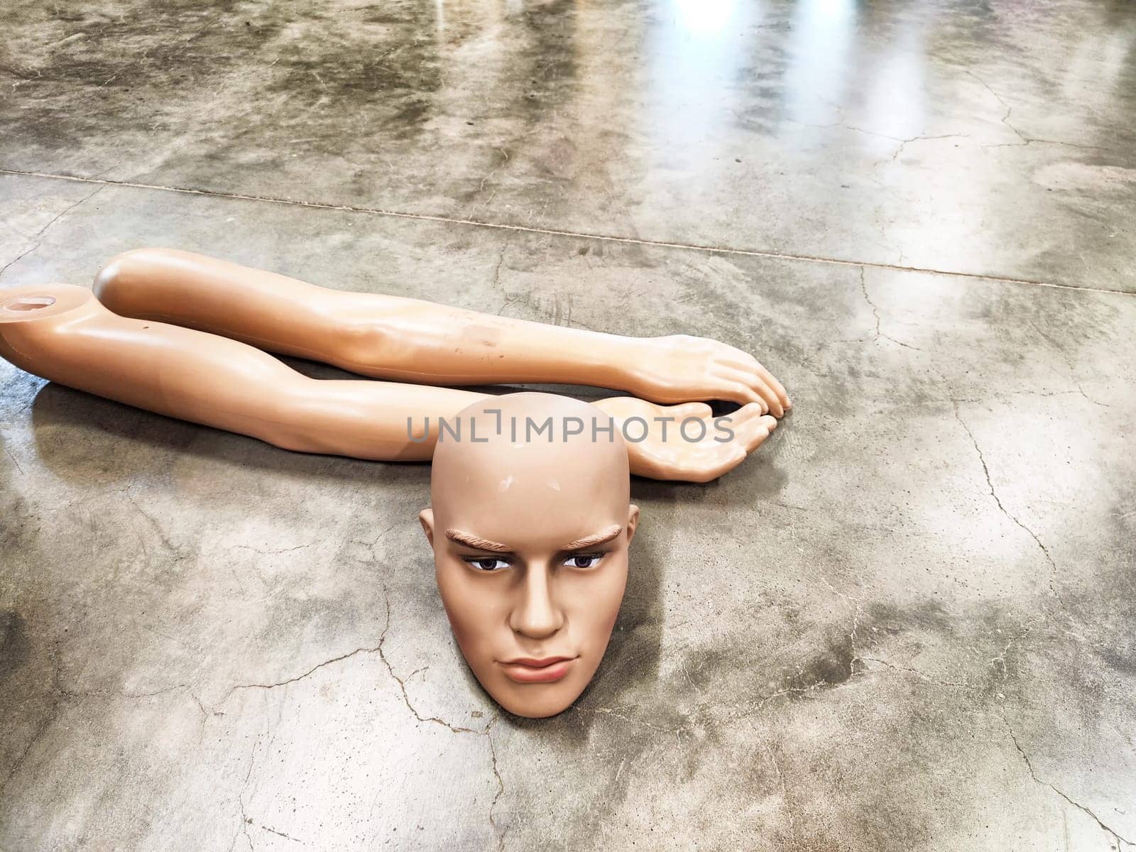 Disassembled Mannequin on Concrete Floor. Mannequin parts scattered on polished surface