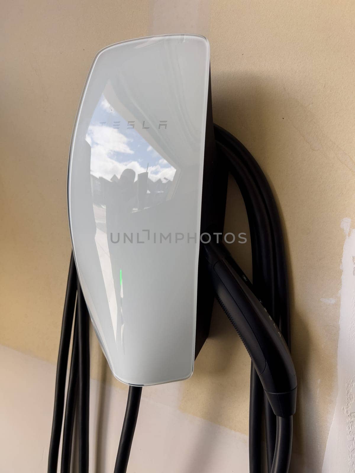 Denver, Colorado, USA-March 28, 2024-Tesla Wall Connector, ready to charge an electric vehicle, is mounted on the wall of a residential garage, showcasing the convenience of home EV charging.