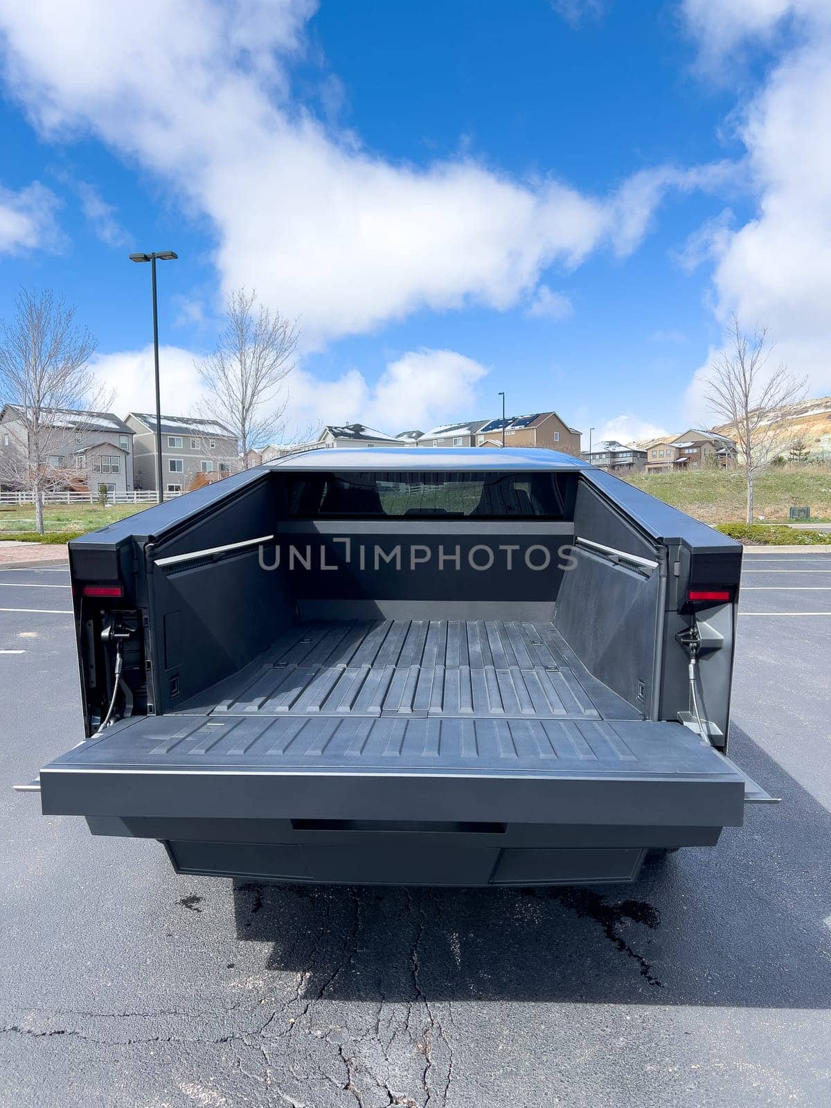 Back View of a Tesla Cybertruck in an Empty Suburban Parking Lot by arinahabich