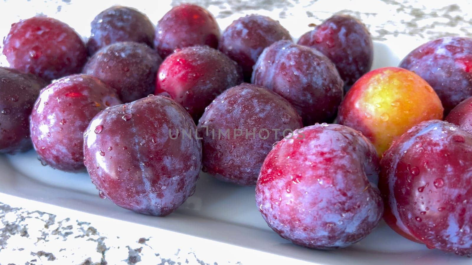 Ripe Plums Arranged on a Kitchen Countertop by arinahabich