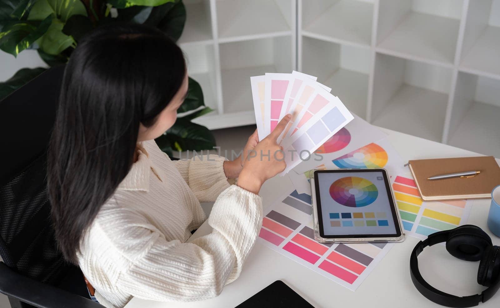 Female designer working in graphic design Choose colors for working on tablets and computer designs. by wichayada