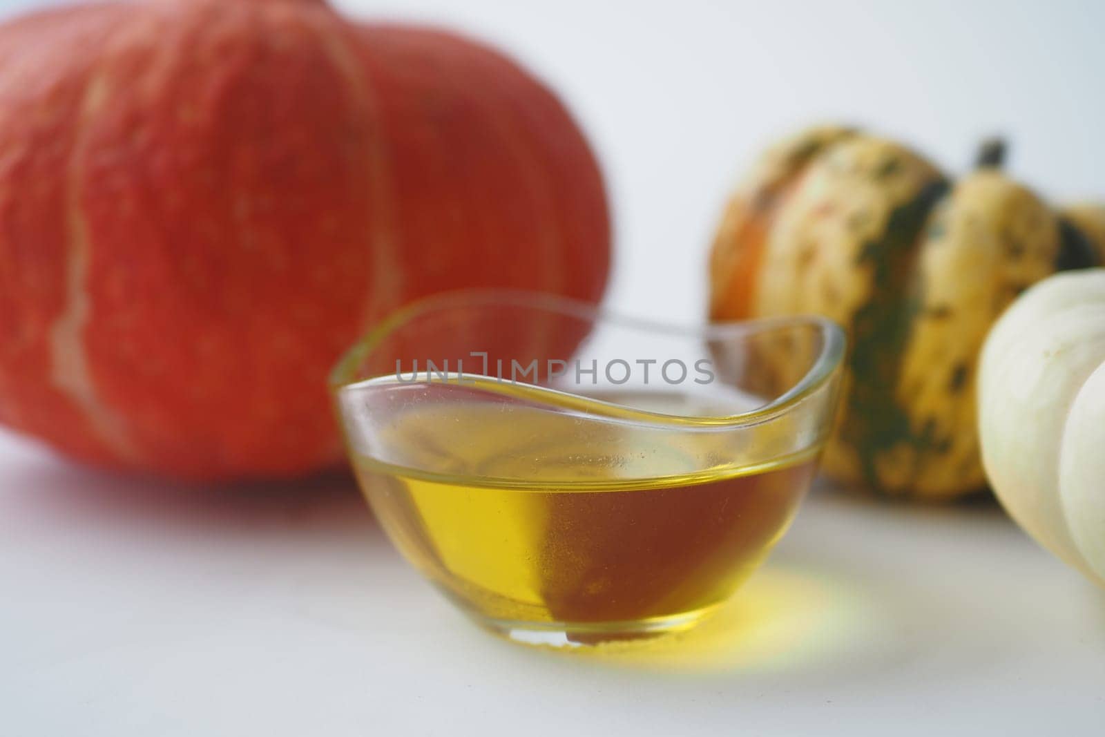 Pumpkin seed oil in glass on white background