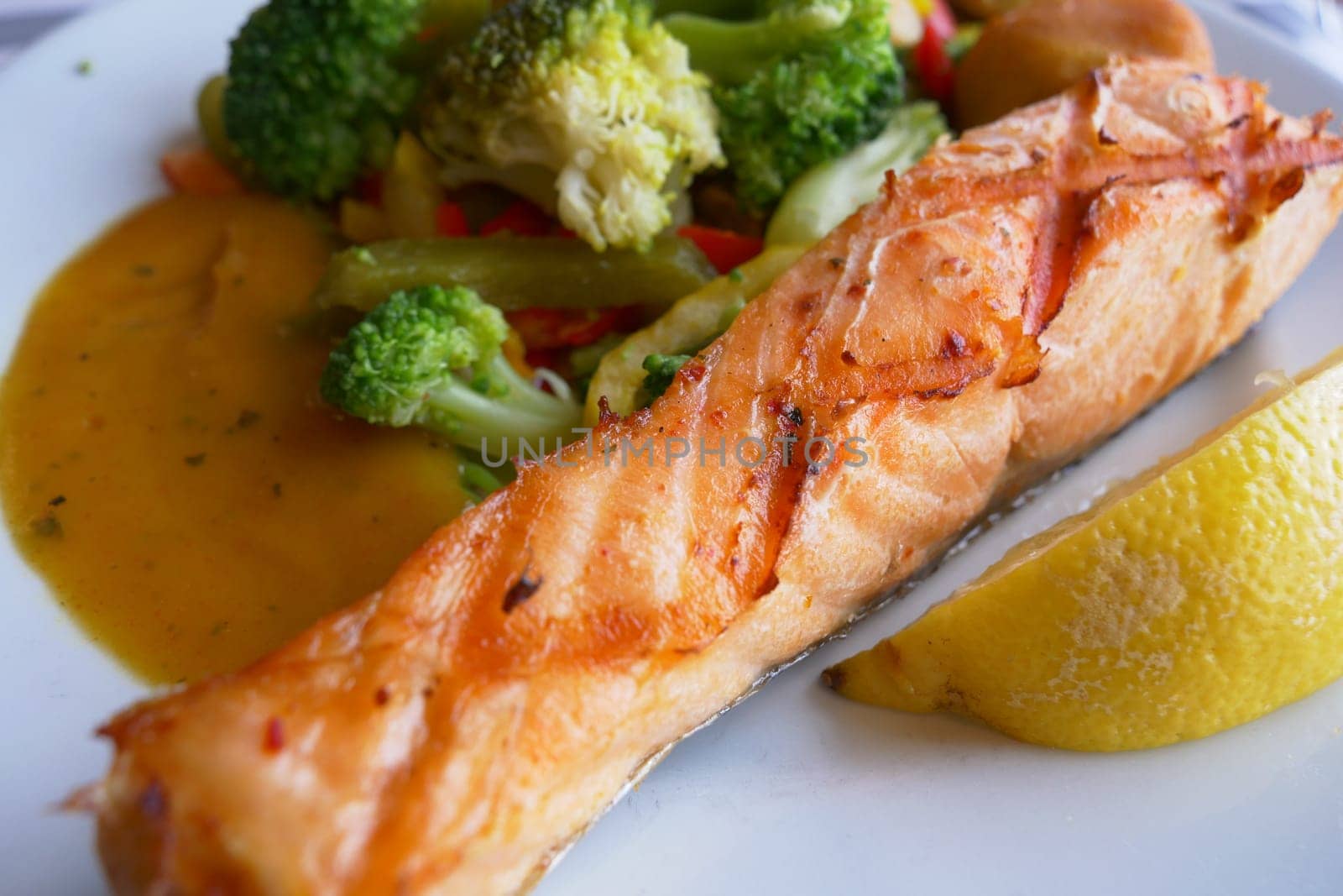 grill salmon served with fresh vegetables on a plate .