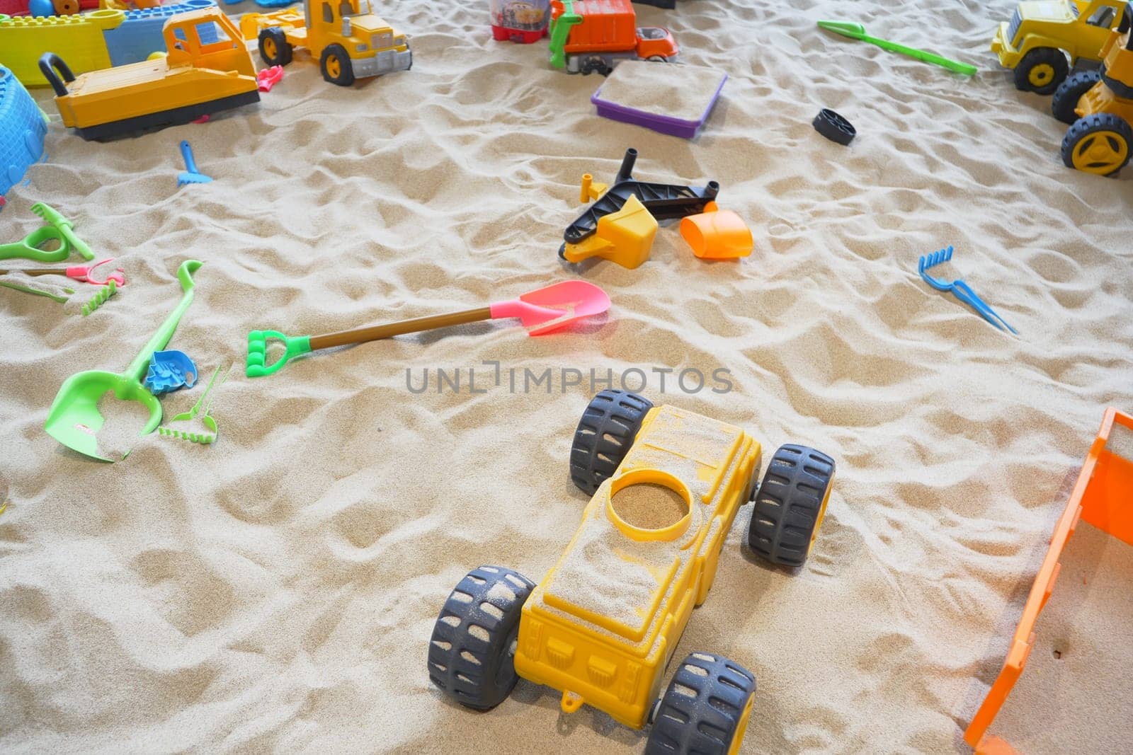 sand and colorful toys in a playground indoors. by towfiq007