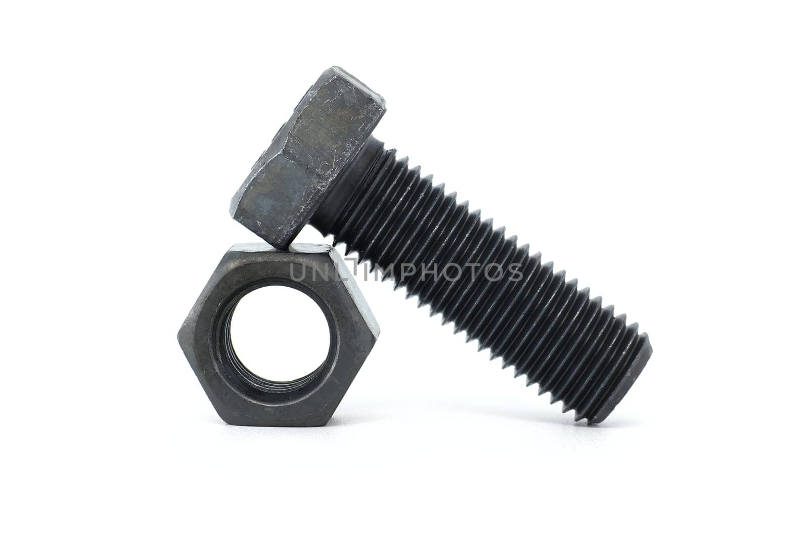 Black metal hexagonal bolt and nut shown in close-up isolated on white background