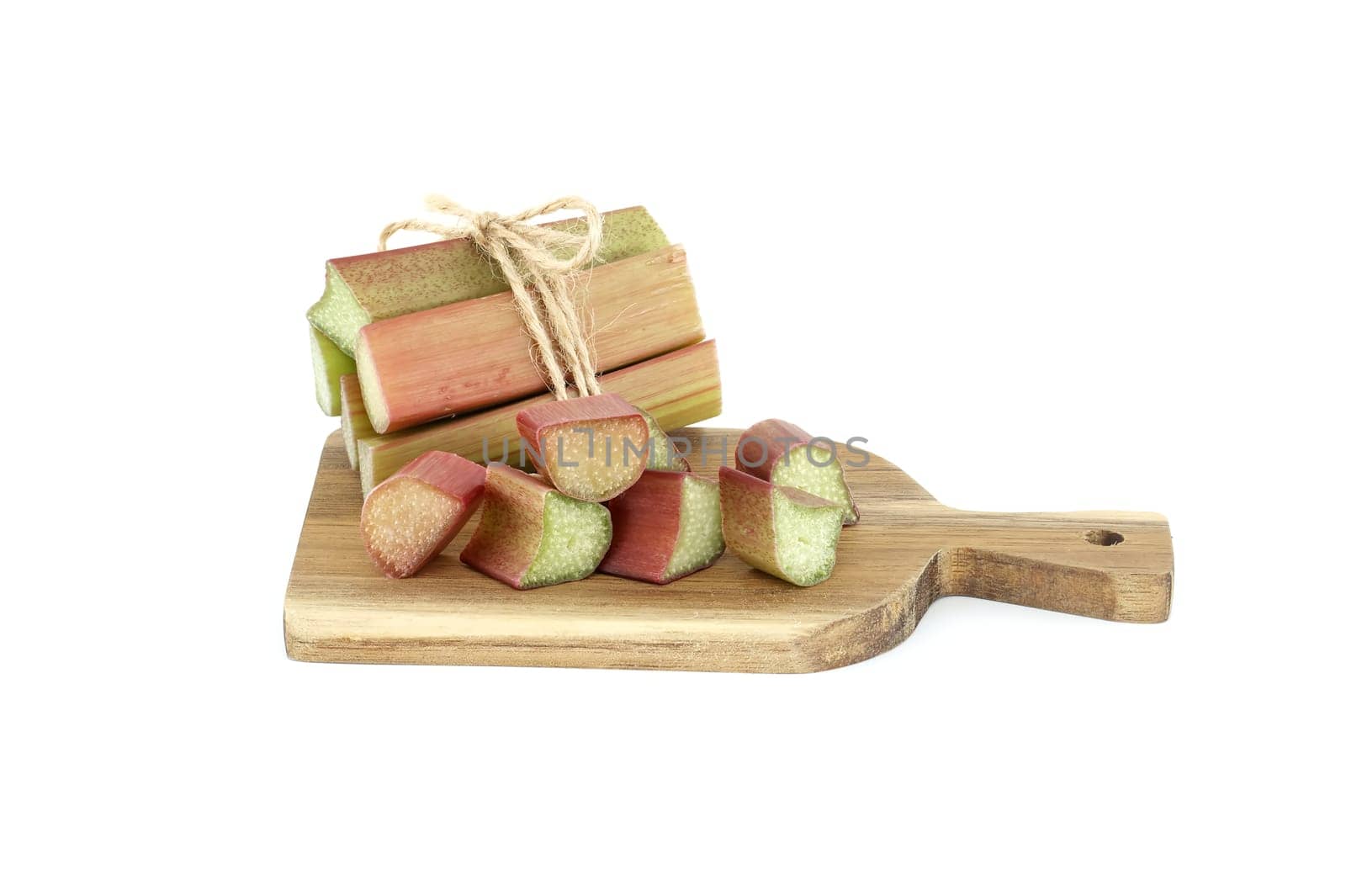 Variety of rhubarb stalks of varying colors from pale green to deep red on wooden cutting board isolated on white background