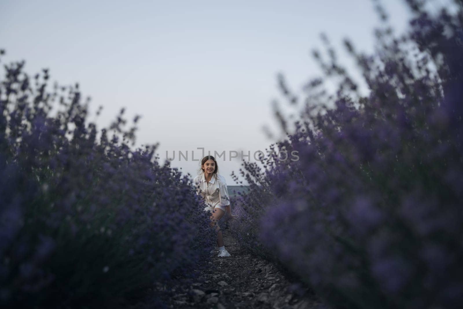 Lavender field happy girl in white dress with a scythe runs through a lilac field of lavender. Aromatherapy travel by Matiunina