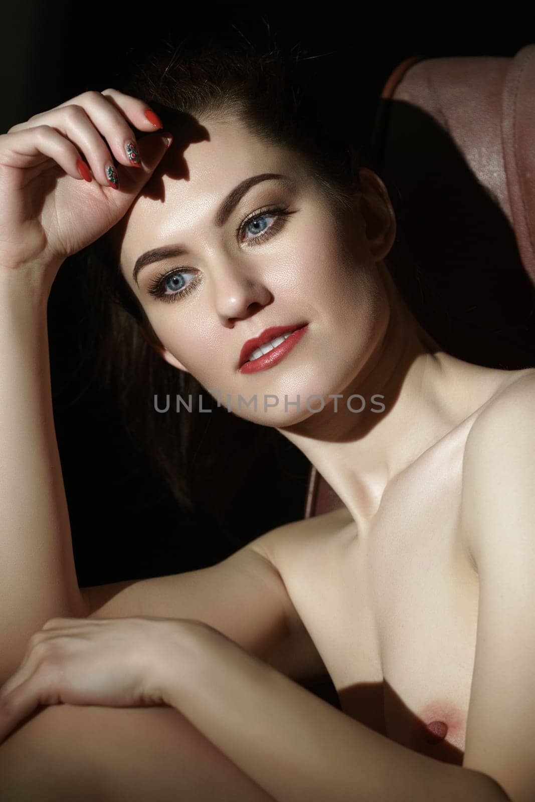 Nude brunette posing with dreamy expression on her face