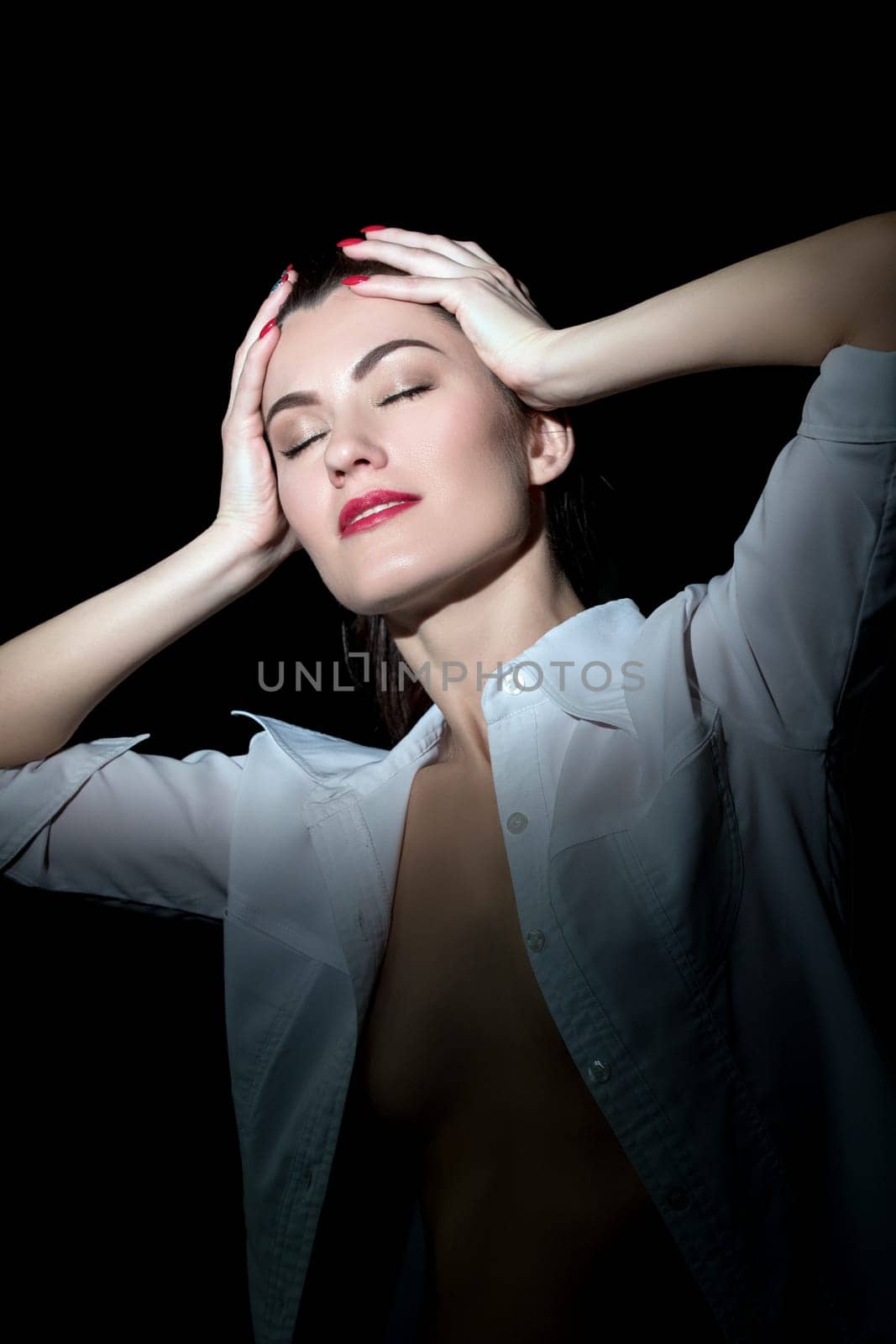 Topless girl in blouse posing while holding her head