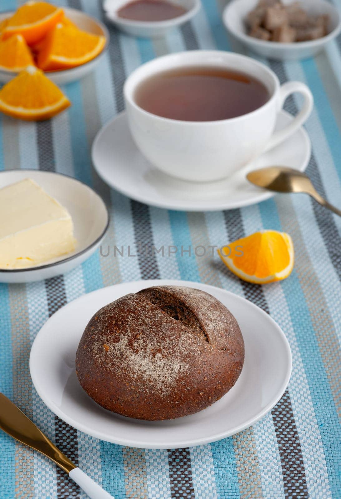 Rye bun and breakfast butter with tea and orange.