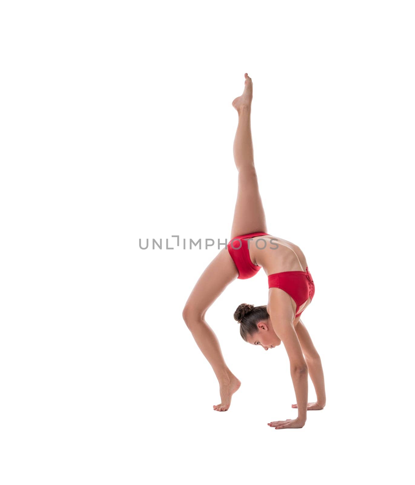 Female athlete performs gymnastic handstand in studio