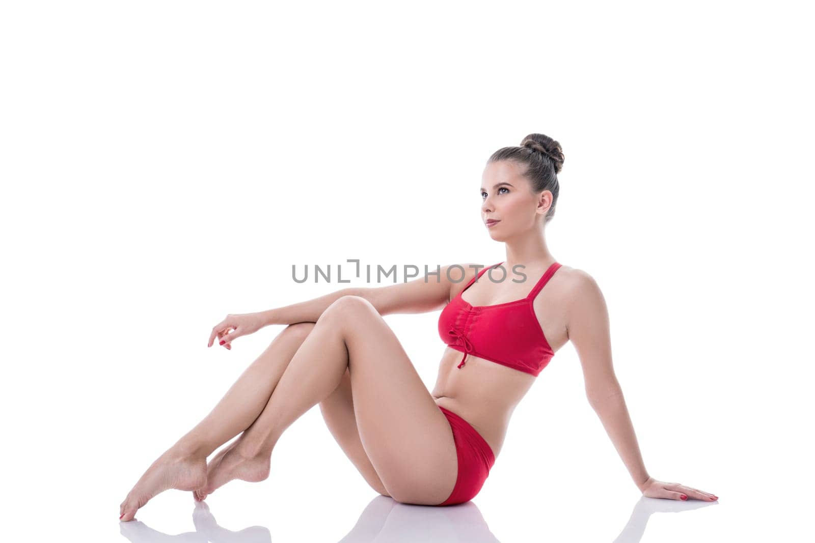 Charming gymnast sitting, pulling her knees to chest