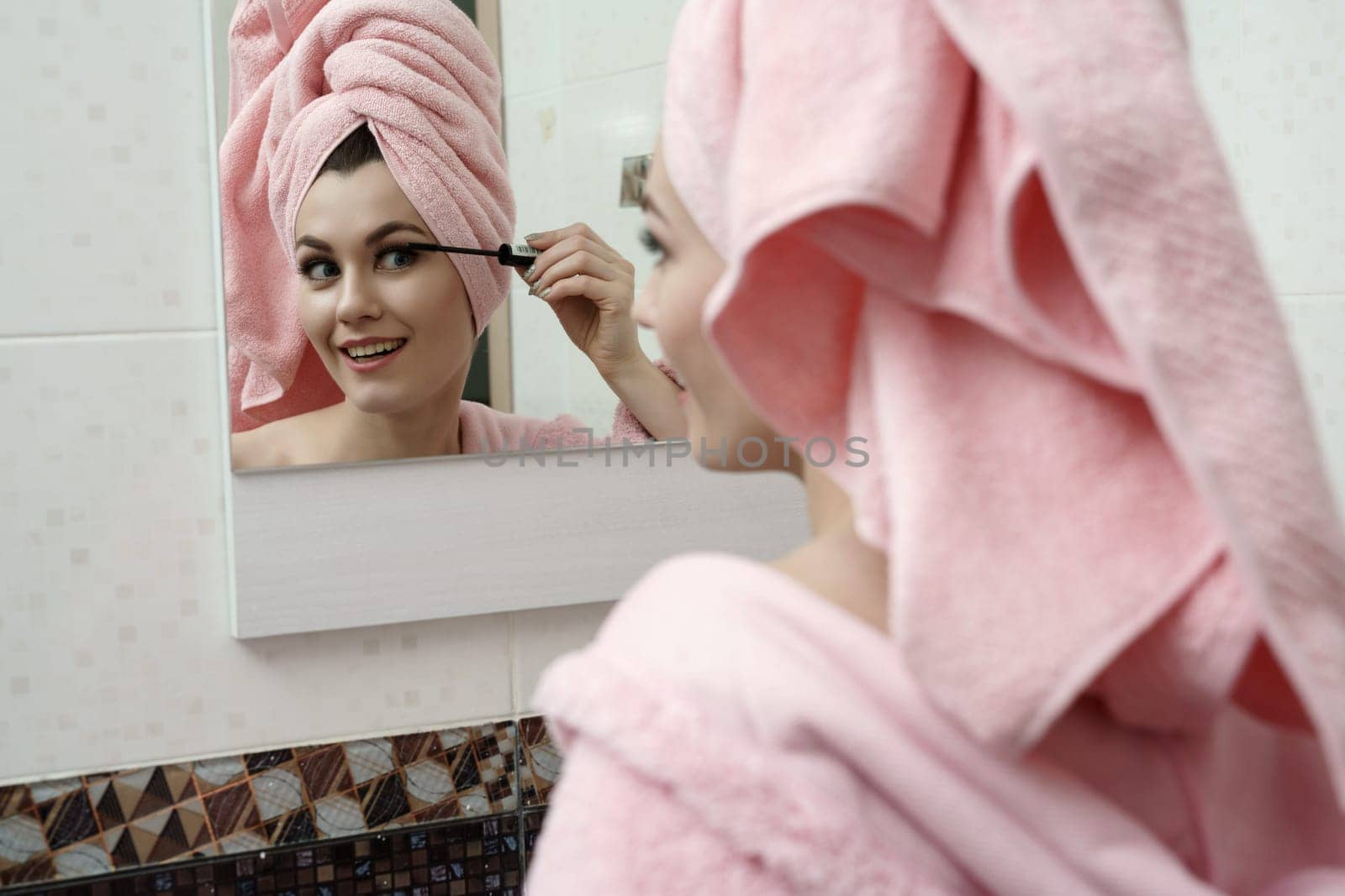 Morning toilette. Image of flirtatious woman using mascara