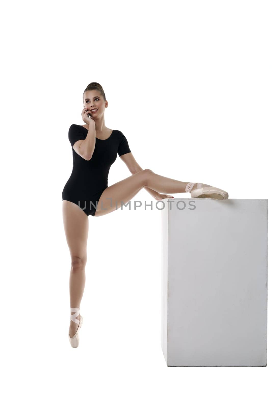 Image of pretty ballerina talking on phone during workout
