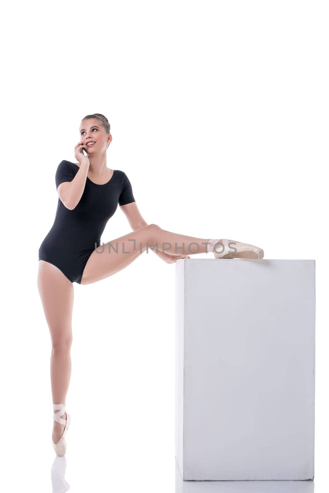 Pretty ballet dancer talking on cellular during rehearsal