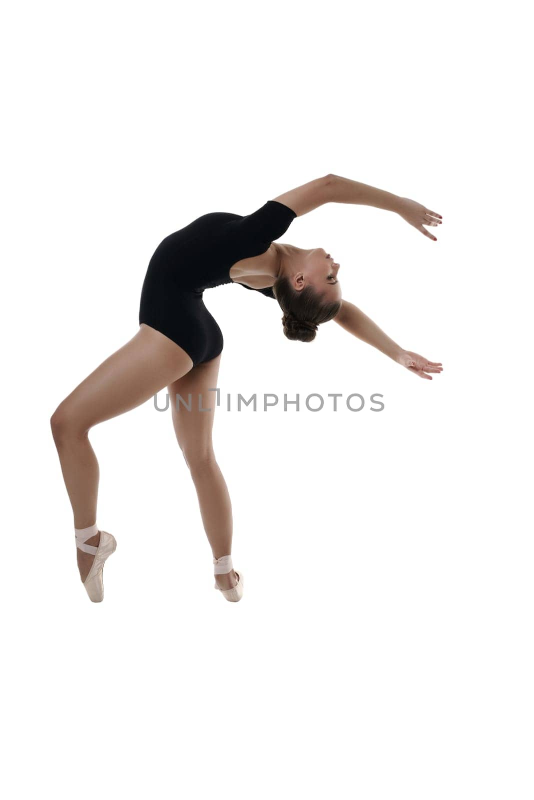 Young ballet dancer posing in graceful position. Studio photo, isolated on white