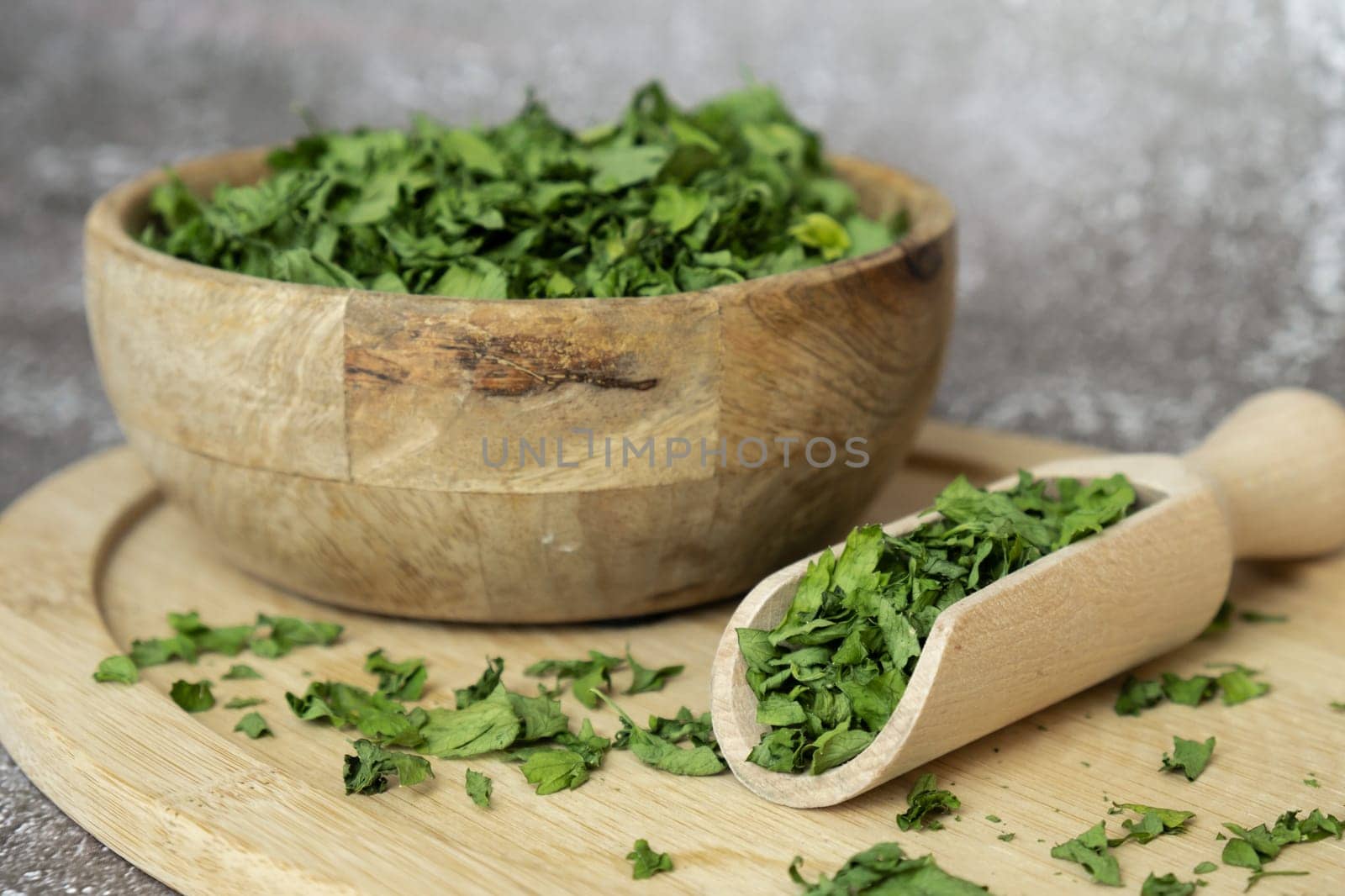 Dry parsley spice with wooden spoon in wooden bowl. Homegrown herbs and spices for cooking. Fresh dried aromatic natural food ingredients by anna_stasiia