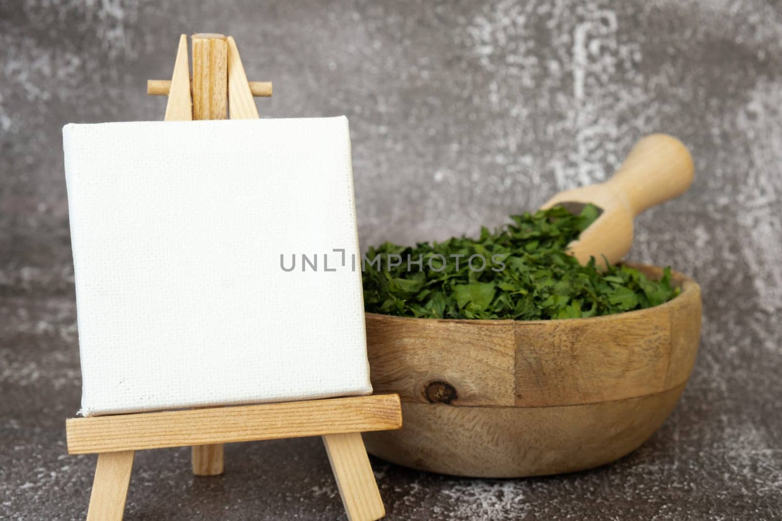 Dry parsley spice in wooden bowl with empty white mock up template. Homegrown herbs and spices for cooking. Fresh dried aromatic natural food ingredients. Copy space