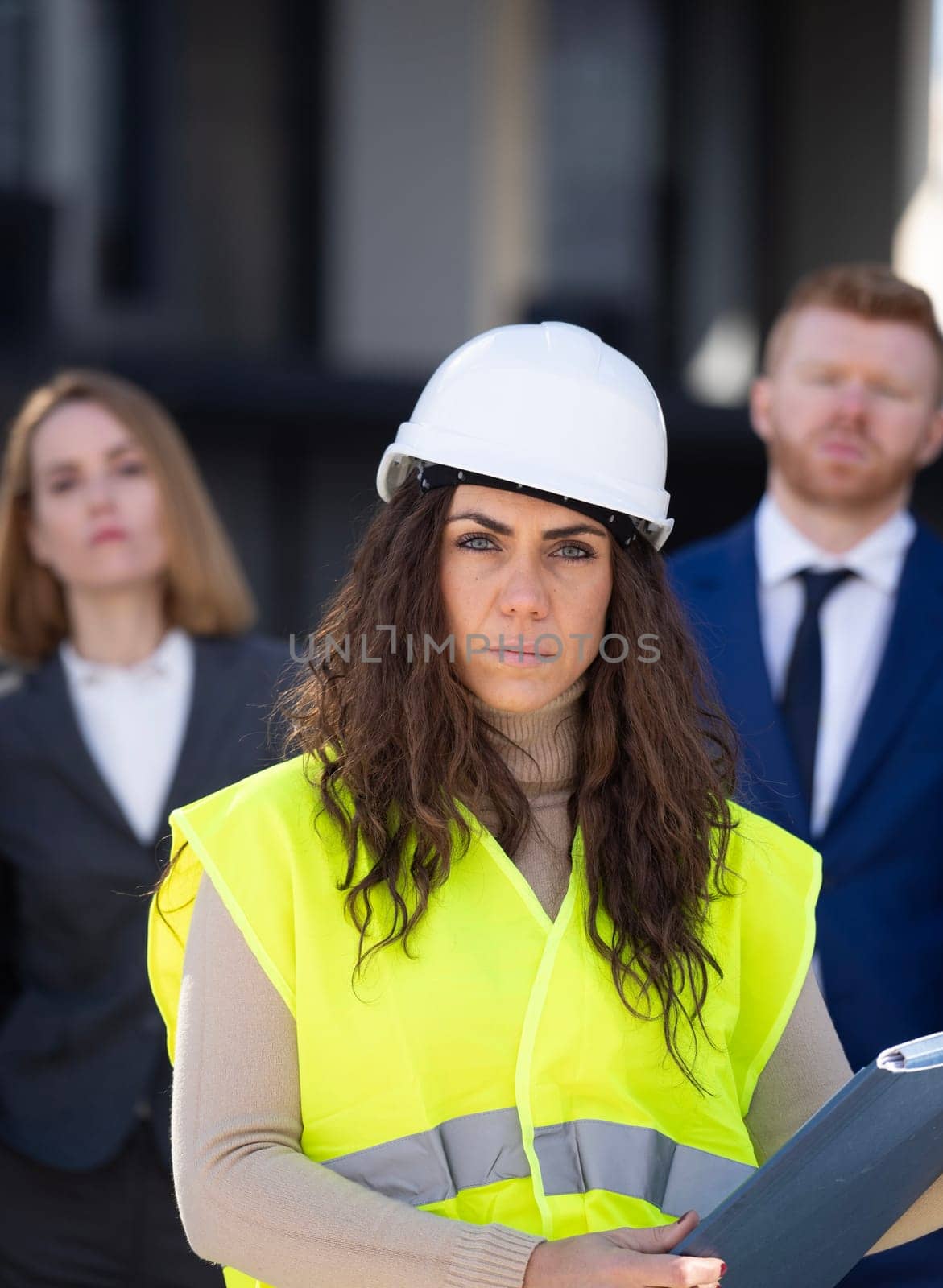 Woman engineering manager is leading a construction in front of their business team.