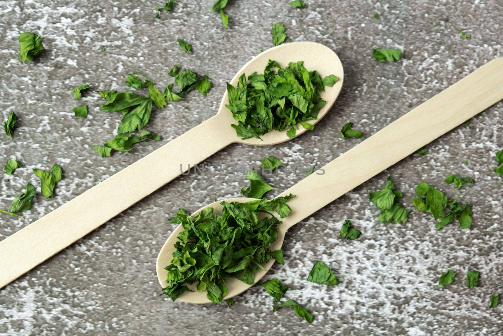 Wooden spoon with green dry parsley. Vegetarian bio organic salad herb healthy eating. Home garden immunity-boosting herbs. Seasonal harvest by anna_stasiia