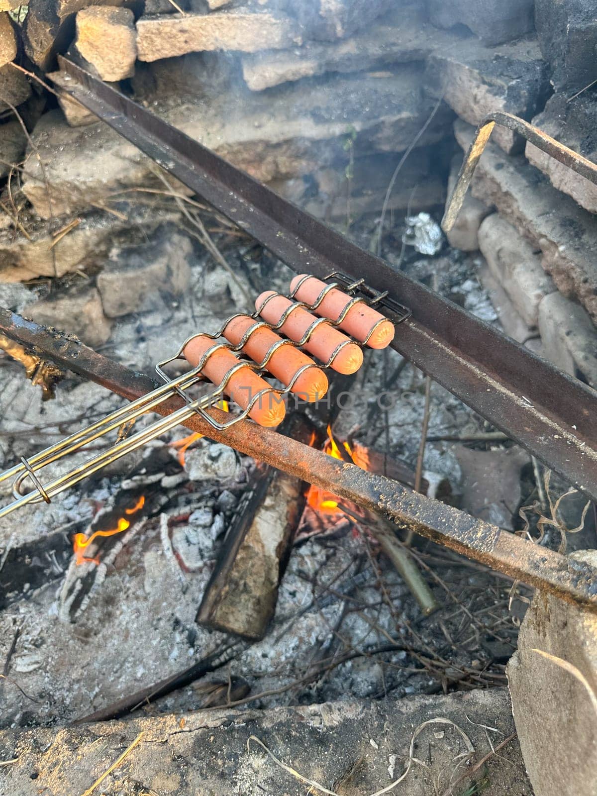 sausages roasting on a fire in summer
