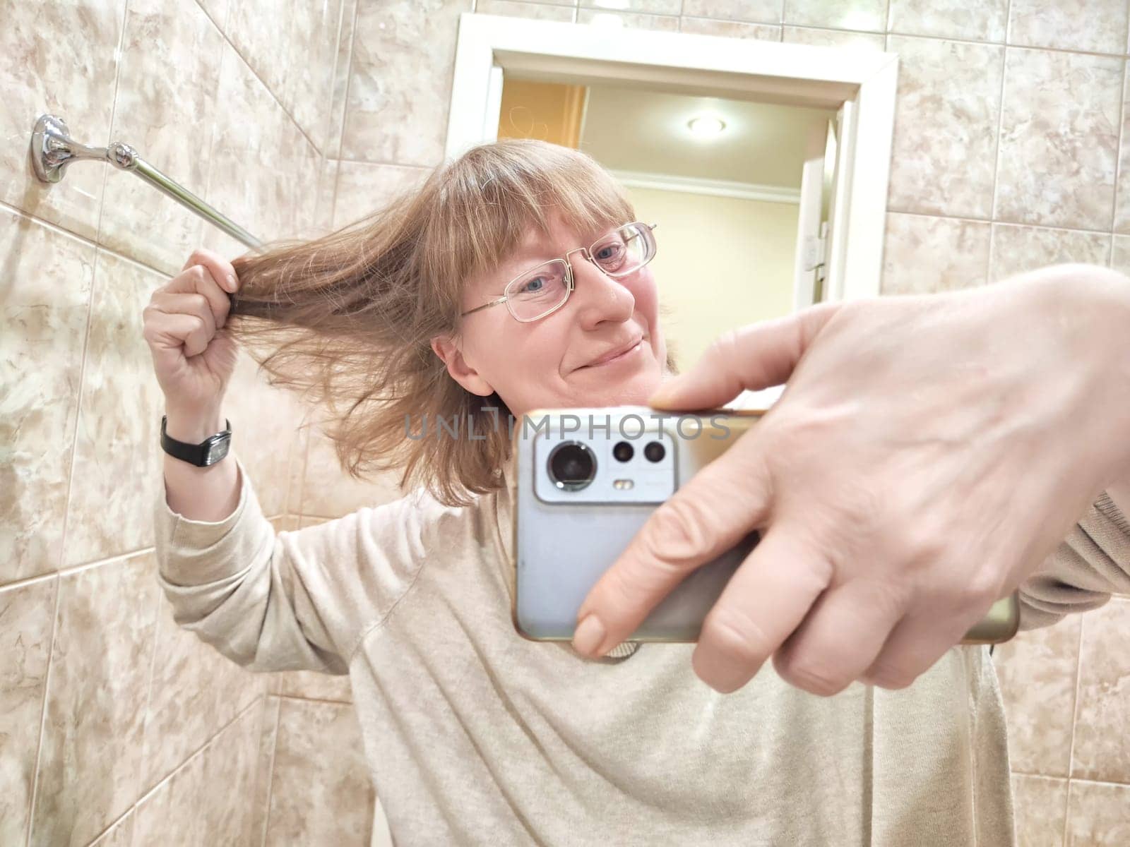 A shaggy, funny middle-aged woman in glasses doing hair and taking Blogger girl posing for blog, stream by keleny