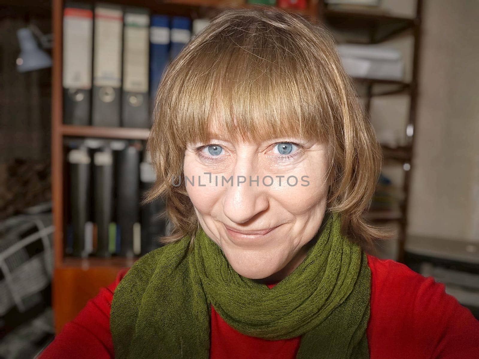 Portrait of a cute blonde girl indoors. Funny middle-aged woman posing and taking selfie indoors by keleny