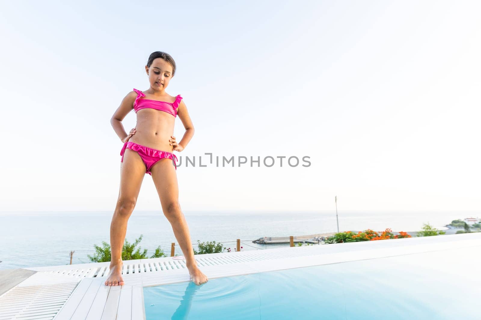 Closeup portrait of cute little arabic girl swimming in the pool, happy child having fun in water, beach resort, summer vacation and holidays concept by Andelov13