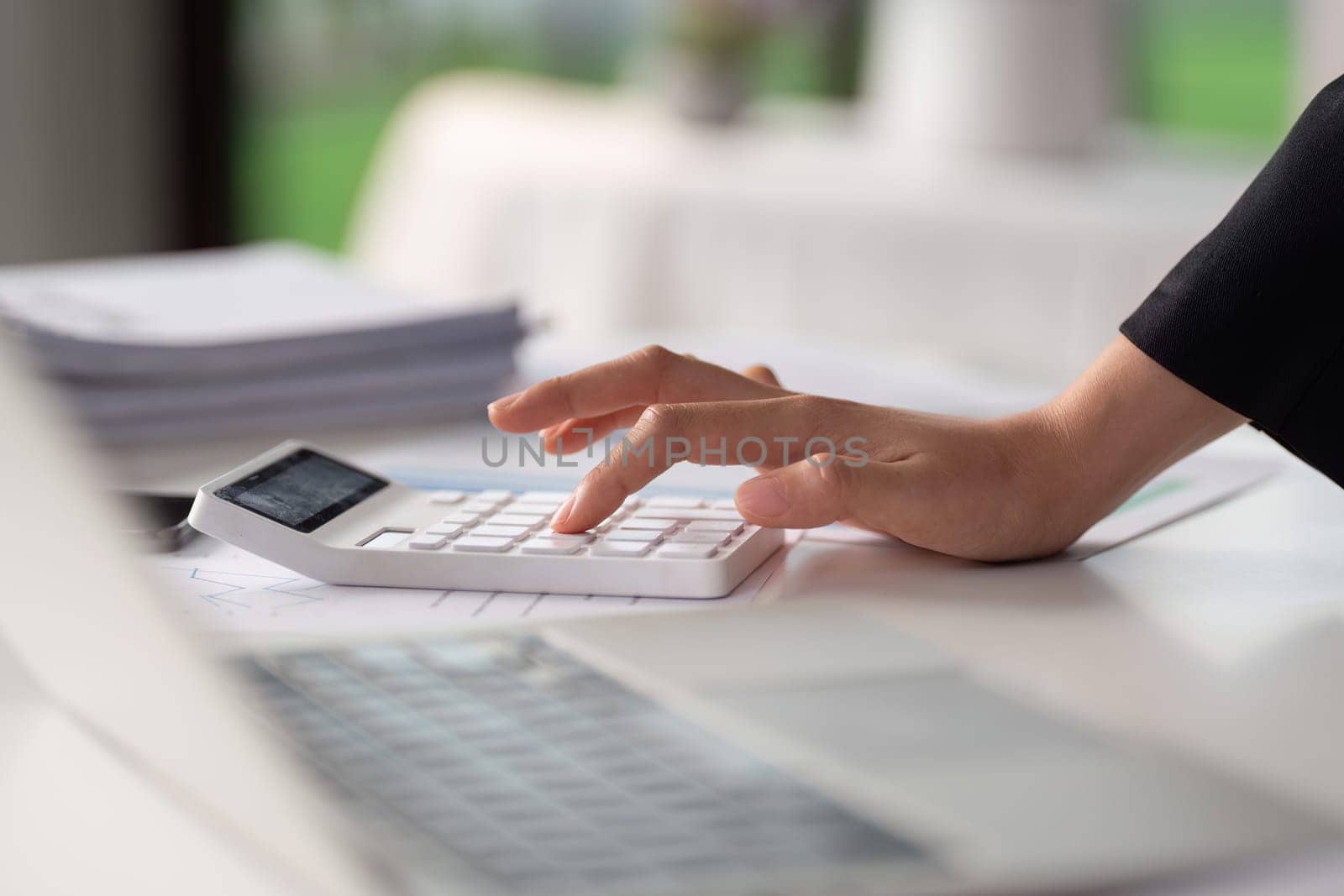 Businesswoman working with document and using calculator for checking finance report by itchaznong