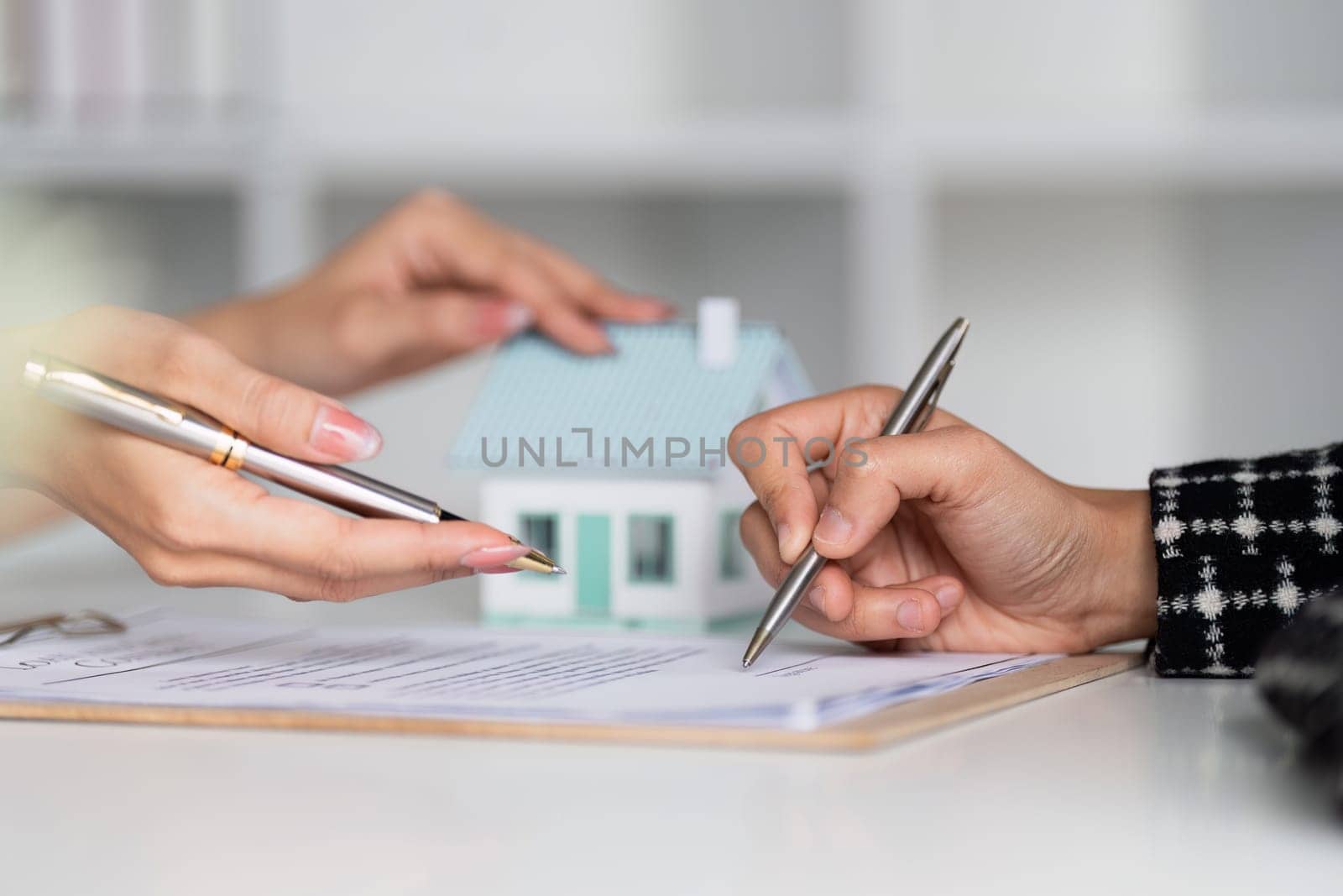 Real estate agent offer hand for customer sign agreement contract signature for buy or sell house. Real estate concept contact agreement concept by itchaznong