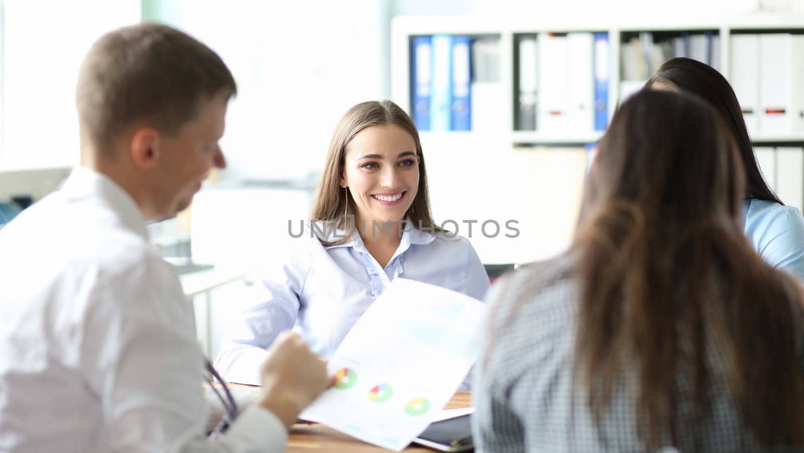 Smiling businesswoman portrait against business people office background. Financial statistics education concept. Discussion together on problem organization