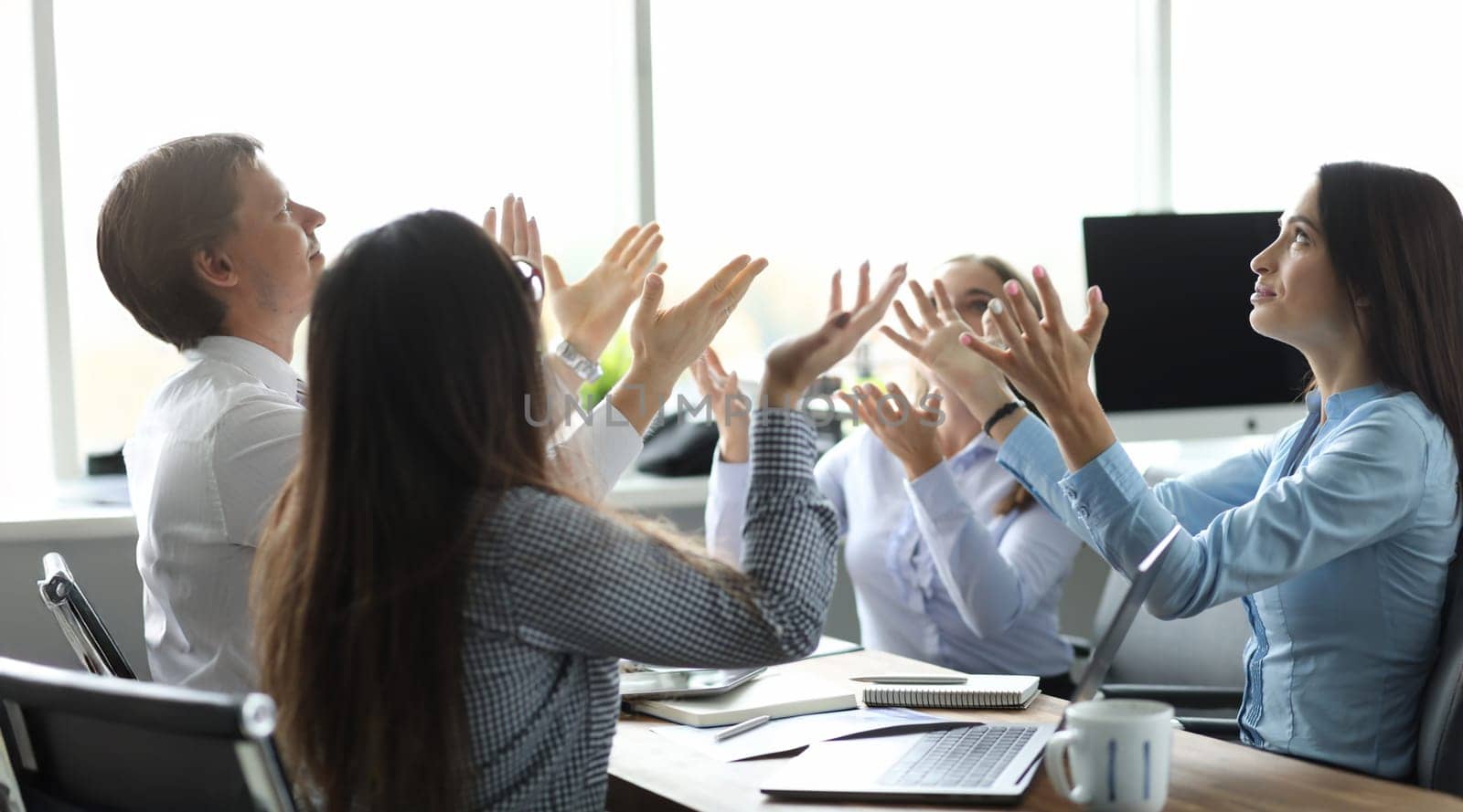 Team of business people raise hand from office background by kuprevich