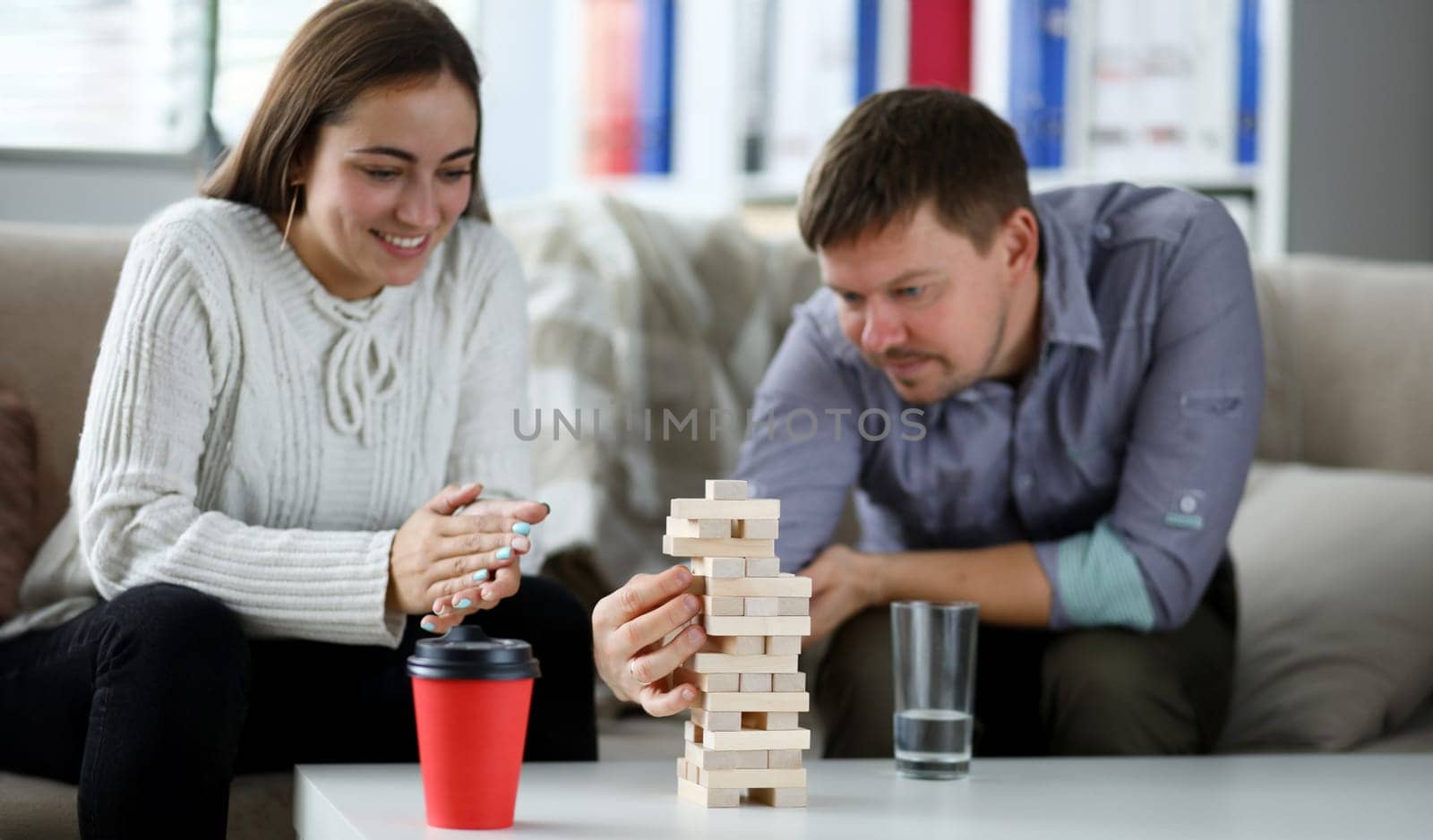 Wife and husbland play in board game. Couple build tower from wood block. Party entertainment concept.