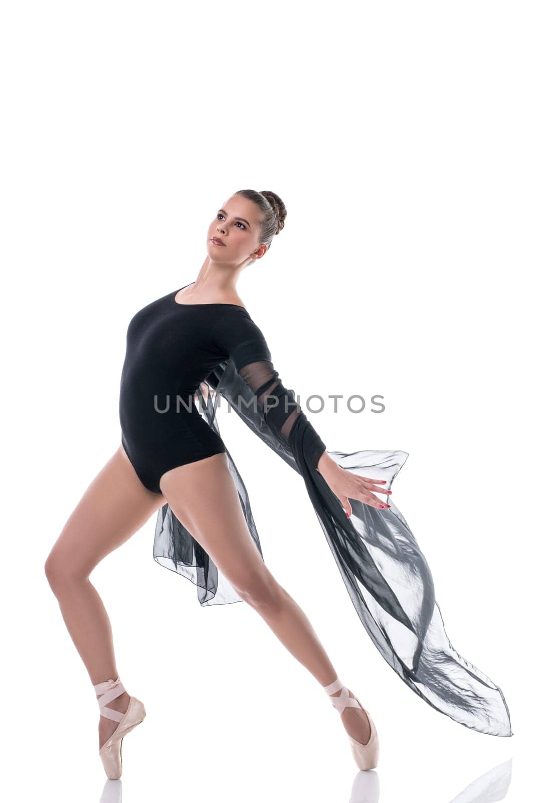 Elegant ballet dancer posing with flying cloth, isolated on white