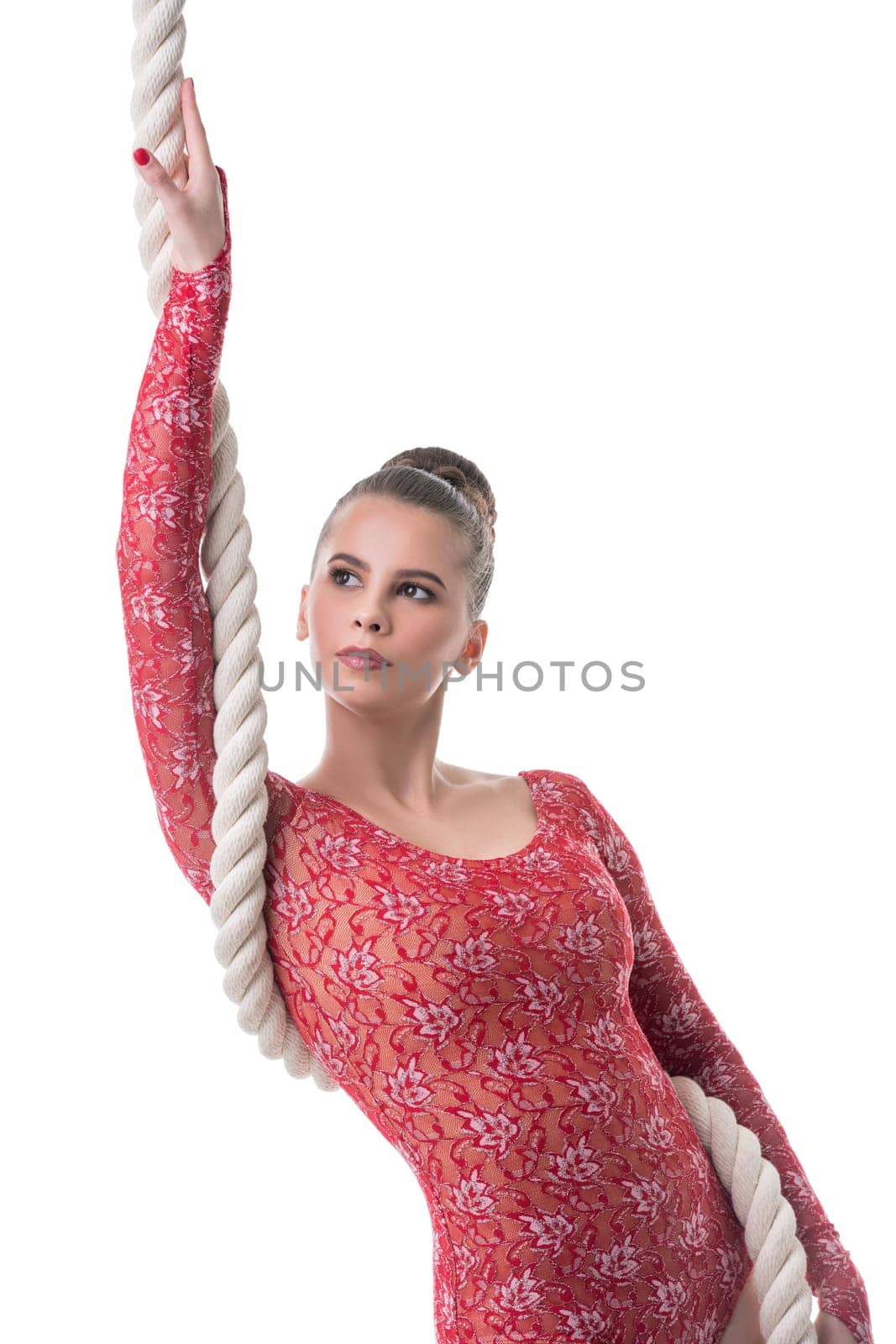 Studio photo of attractive dark-haired gymnast posing with rope