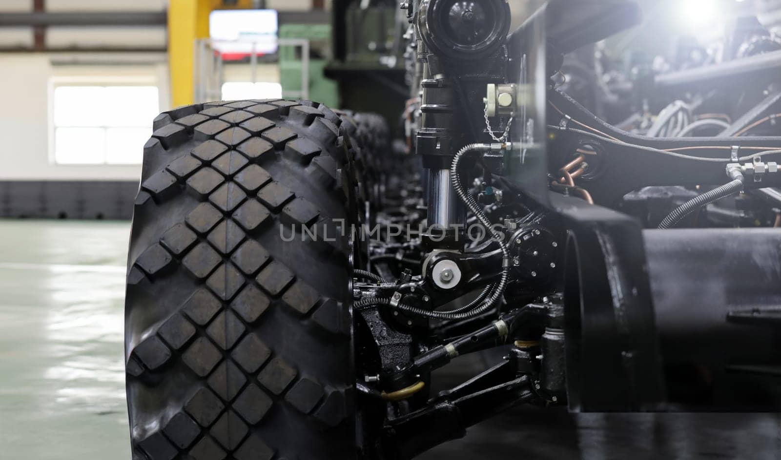 Close-up of new suspension system and shock absorber of car with wheel. Automotive part of atv off road. Mechanical engineering industry concept. Blurred background