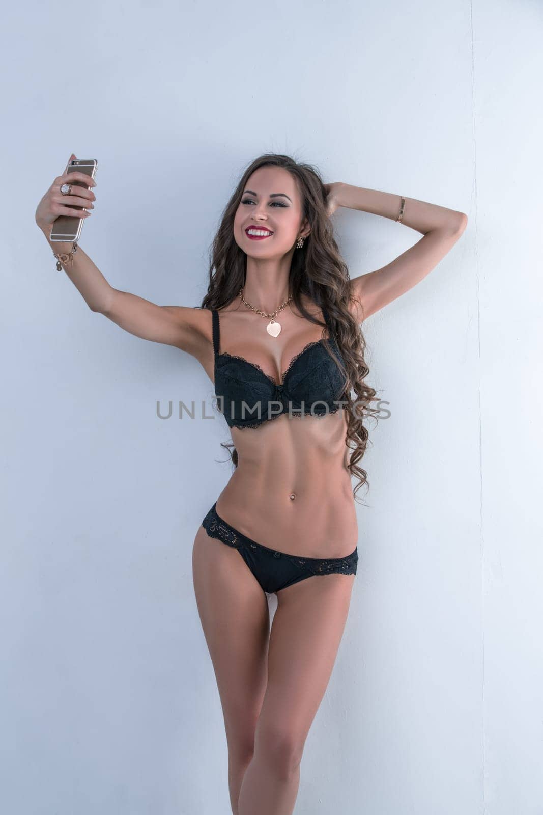 Sexy model in underwear doing selfie on her smartphone