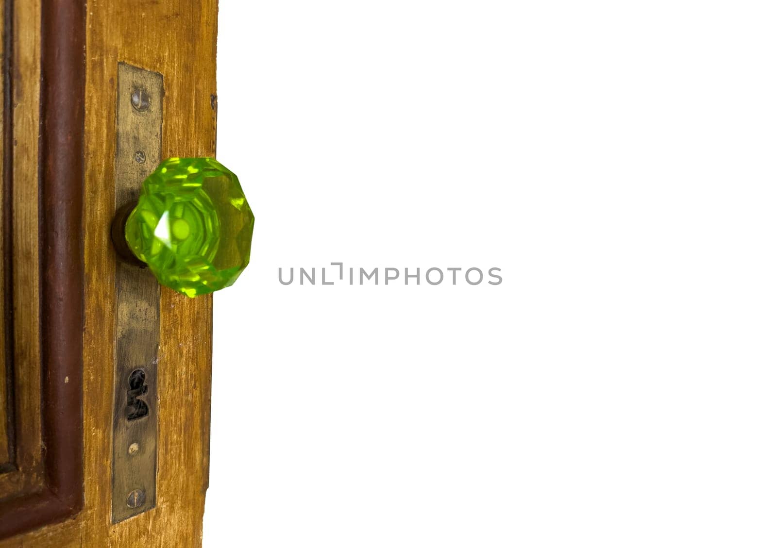 Classic green glass door knob with detailed design on wooden door.