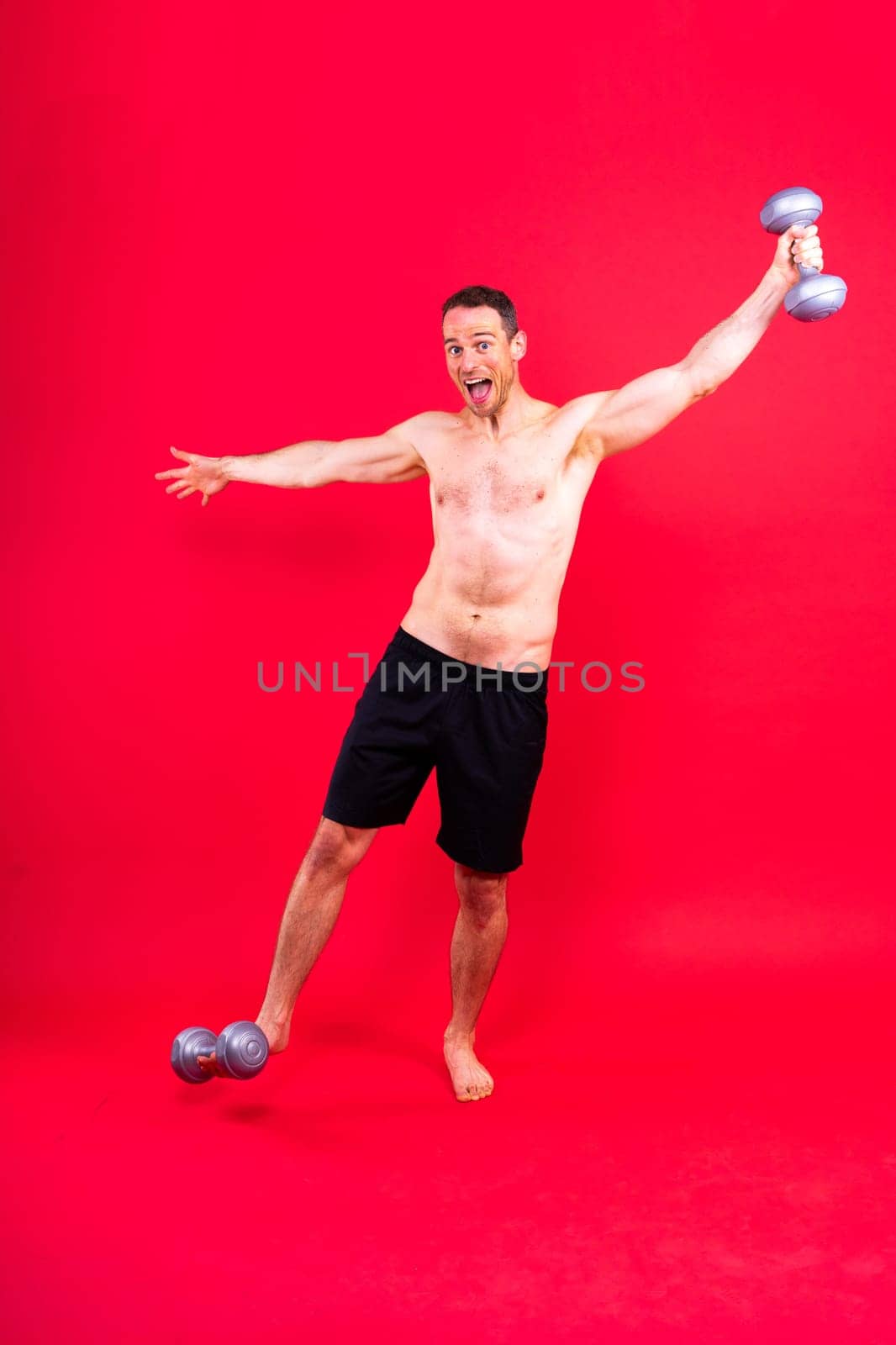 Exercising weight training man with a dumbbell isolated studio background, sport and fitness concept by Zelenin
