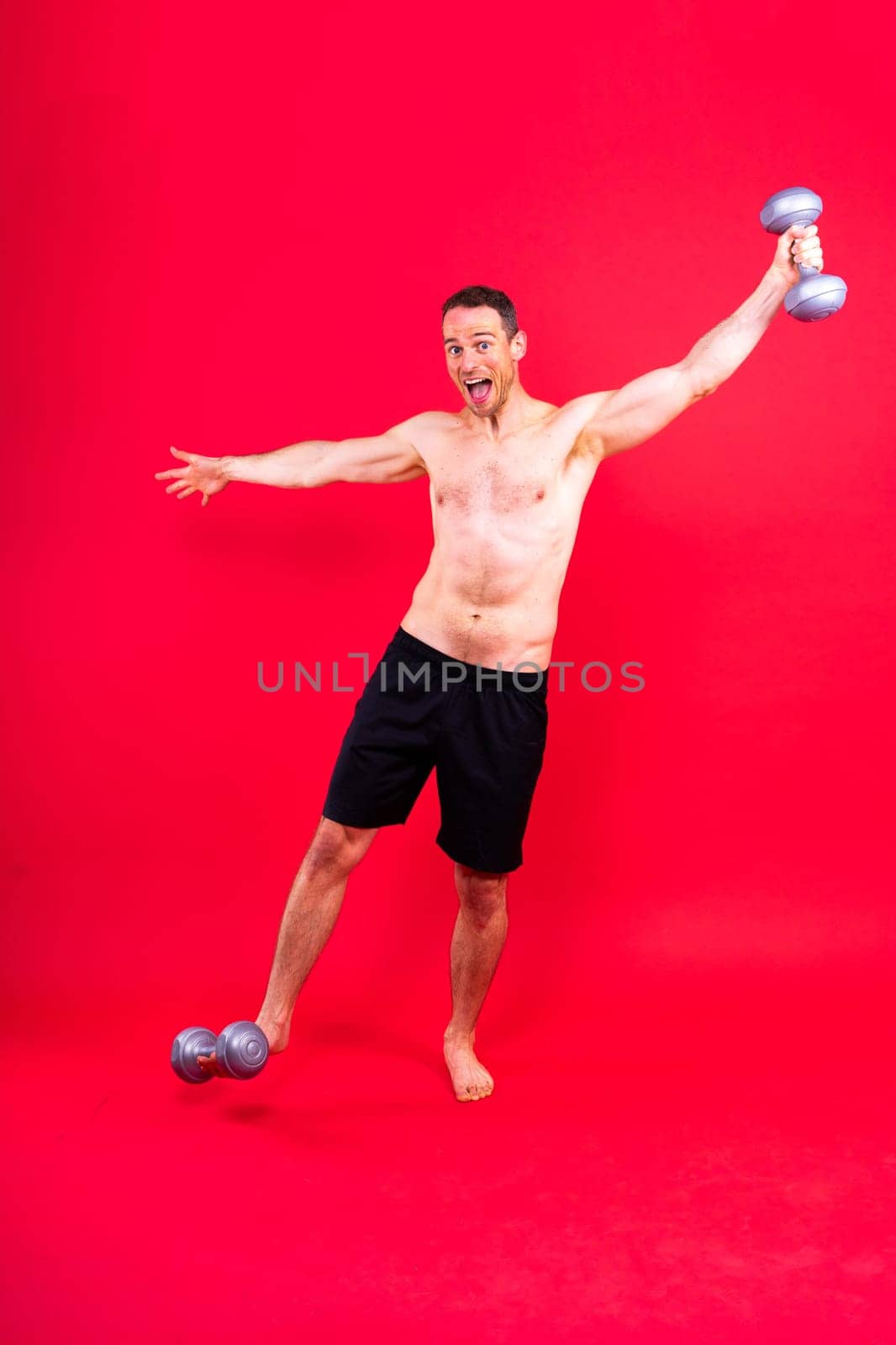 Exercising weight training man with dumbbell isolated on studio background, sport and fitness concept