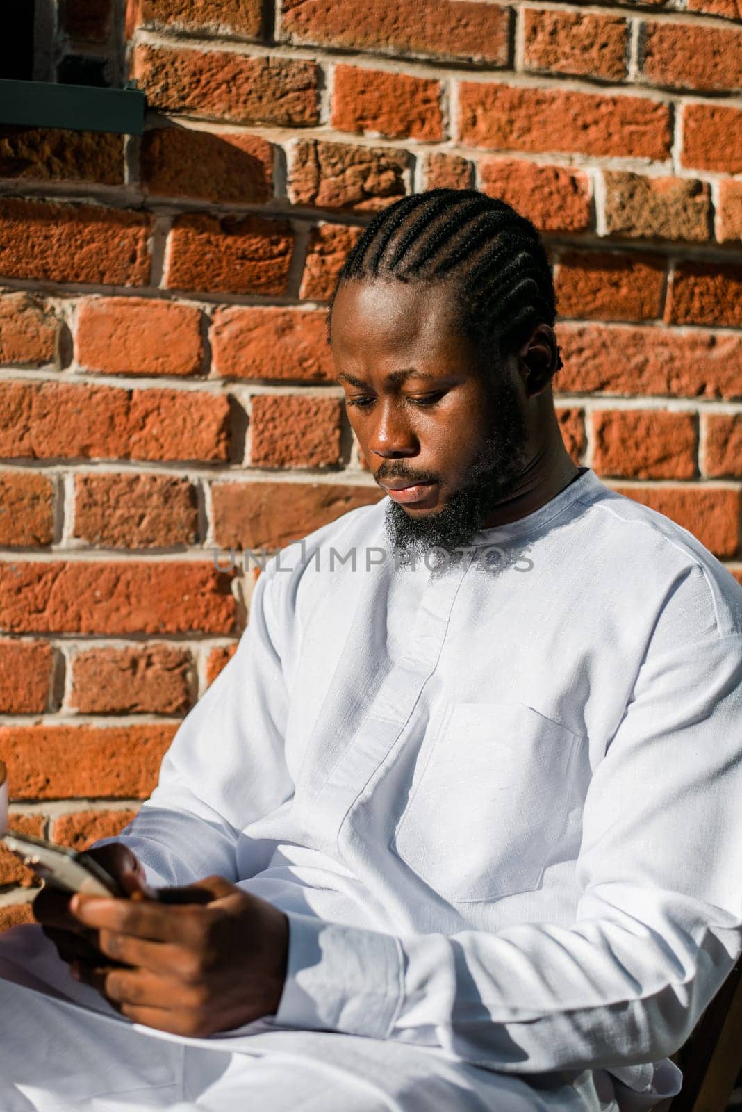 Millennial generation african american man typing sms outdoor 5g internet concept. High speed internet on phone and chatting on social networks and blog