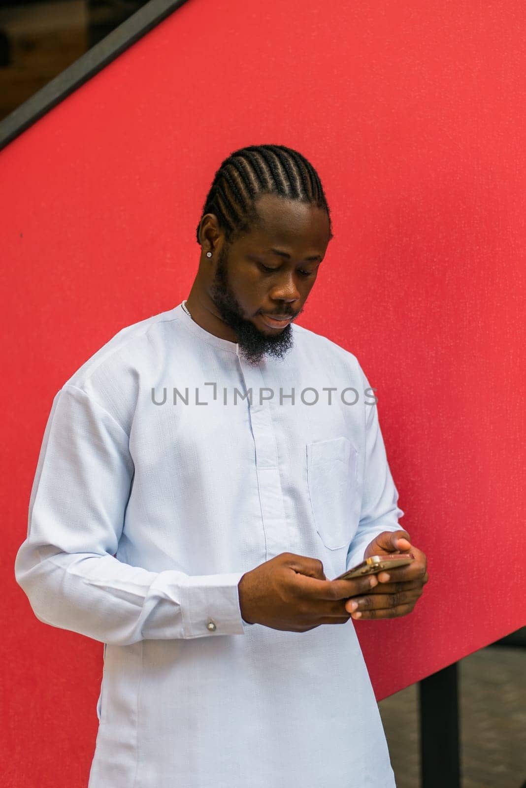 Millennial generation african american man typing sms outdoor 5g internet concept. High speed internet on phone and chatting on social networks and blog concept by Satura86