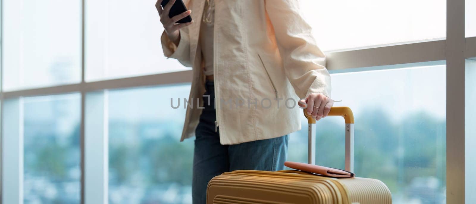 A woman asian walking in an airport. Mobile, suitcase and travel with a young female on an trip for work or travel.