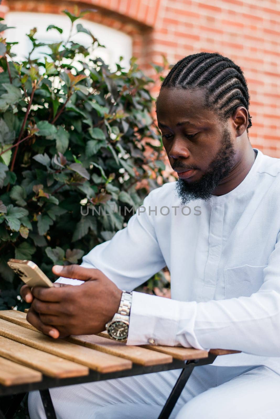 Millennial generation african american man typing sms outdoor 5g internet concept. High speed internet on phone and chatting on social networks and blog concept by Satura86