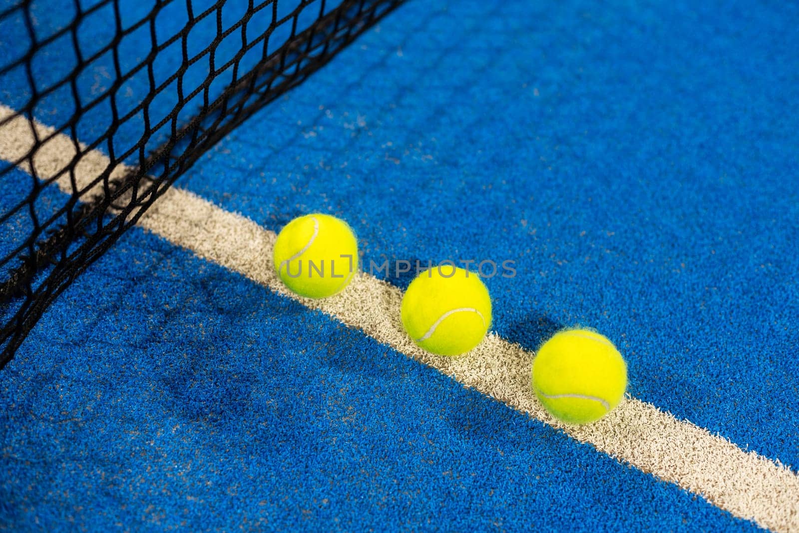 paddle tennis racket and balls on the blue paddle court. High quality photo