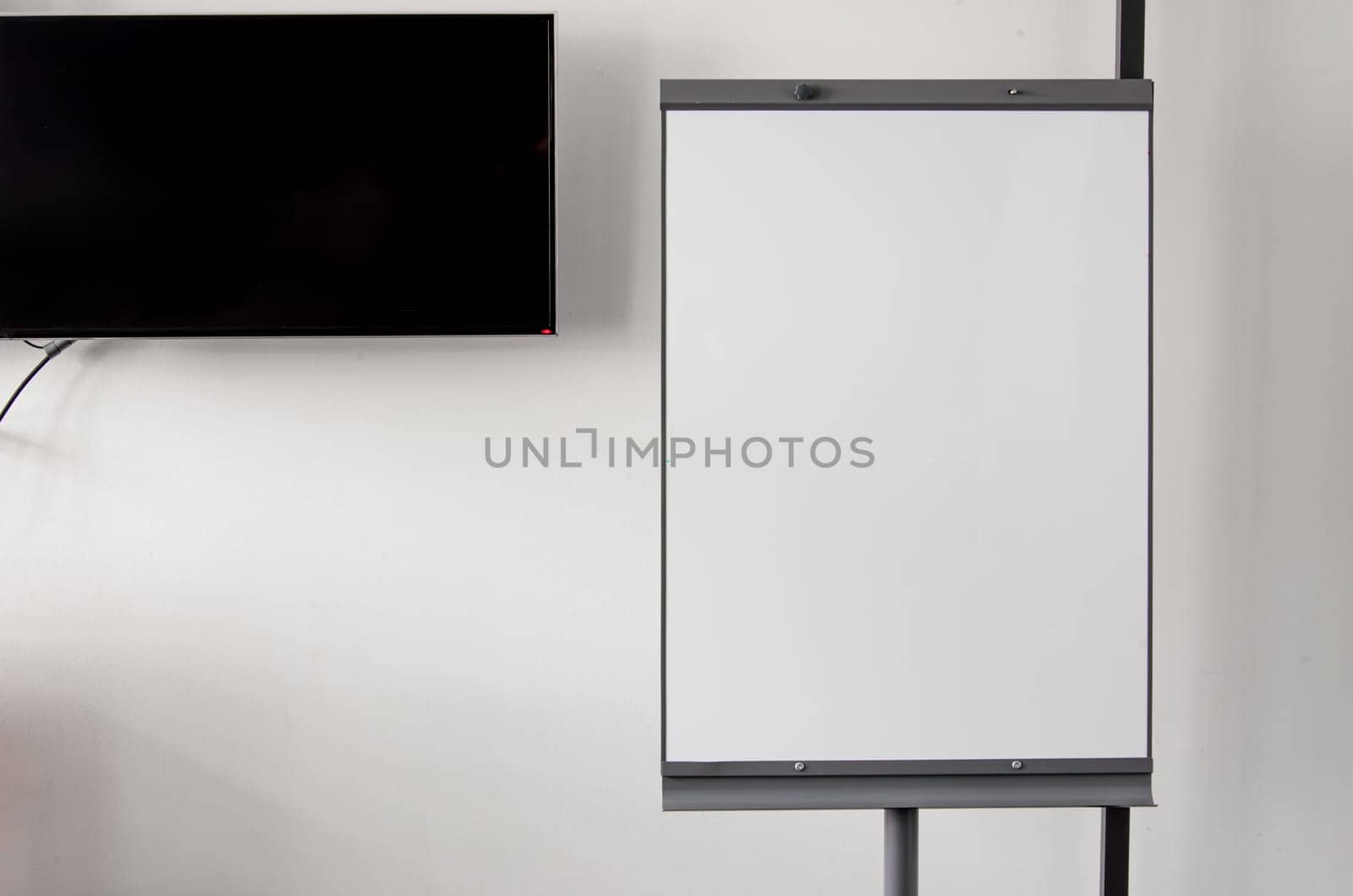 White board or flipchart on white wall background. Background, place for text, copy space.